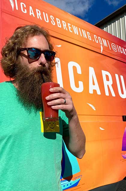 Person drinking in front of Icarus Brewing van
